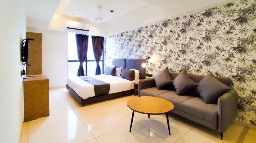 a living room with a couch and a bed at Hotel Nova Bizz in Rajkot