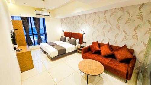 a living room with a couch and a bed at Hotel Nova Bizz in Rajkot