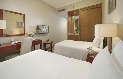 a hotel room with two beds and a desk at City Hotel Xiamen-Free Welcome Fruits in Xiamen