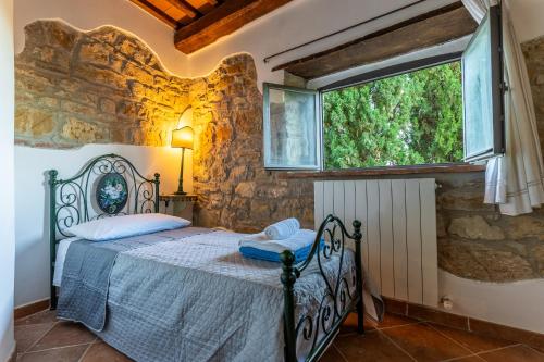 a bedroom with a bed in a stone wall at Bellaria Apartments - Chianti View, Swimming Pool, Nature in San Sano