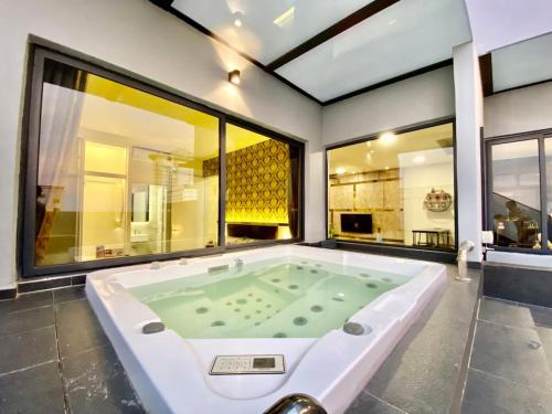 a jacuzzi tub in a room with large windows at Imperio Residence Melaka in Melaka