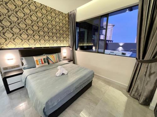 a bedroom with a bed with a white towel on it at Imperio Residence Melaka in Melaka