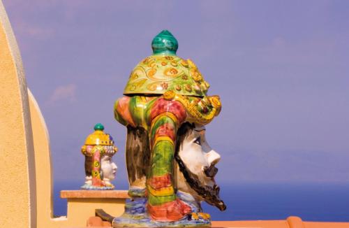 a colorful statue of a head on a shelf at Baia Taormina - CDSHotels in Forza dʼAgro