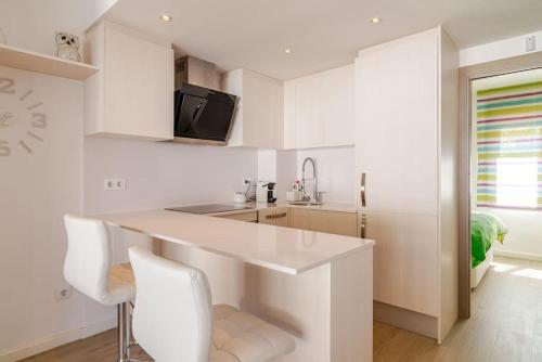 une cuisine blanche avec un comptoir et un évier dans l'établissement Piso reformado a pie de playa Sa Riera Begur, à Begur