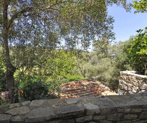 a stone wall with a tree in the background at Adamantia Newly Built Room A3 in Gaios