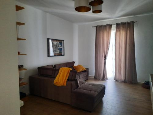 Una sala de estar con un sofá y una silla y una ventana. en Il filo di Arianna, en Putignano