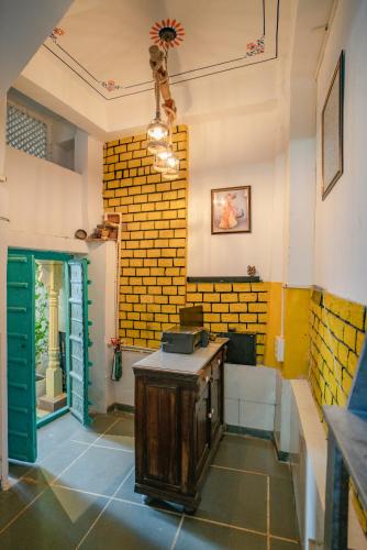 a room with a table and a brick wall at Soham Haveli Udaipur in Udaipur