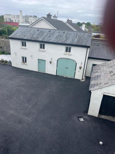 a white garage with blue doors and a parking lot at Ashmore House Cashel in Cashel