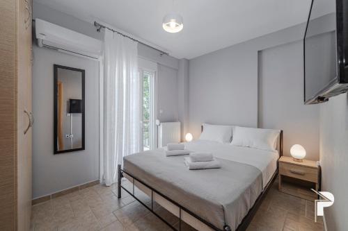 une chambre avec un grand lit avec deux serviettes dessus dans l'établissement P Deluxe Suites A4, à Néa Michanióna