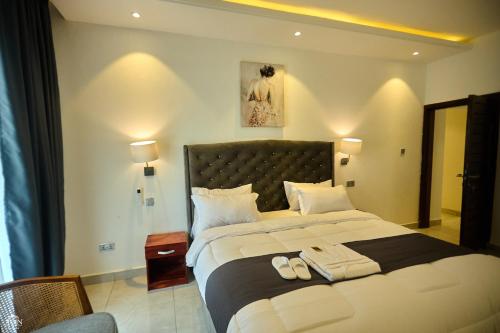 a bedroom with a large bed with two towels on it at AIDEN HOMES AND APARTMENTS HOTEl in Koforidua