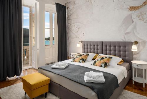 Un dormitorio con una cama grande y un taburete amarillo. en Romeo and Juliet Apartment with Balcony and Sea View, en Poreč