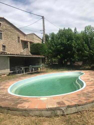 a small swimming pool in a yard with a house at Studio Pic St Loup in Valflaunès