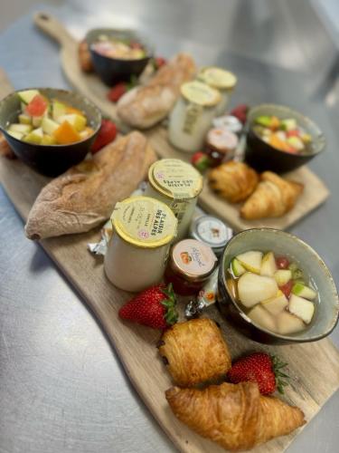 a tray of food with fruit and pastries on a table at Le Domaine de la mer - Appartements de plage dans un cadre enchanteur in Hyères