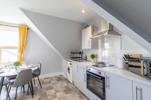 a white kitchen with a table and a dining room at Open Mind Property - Cosy Apartment with 2 Beds in Portsmouth