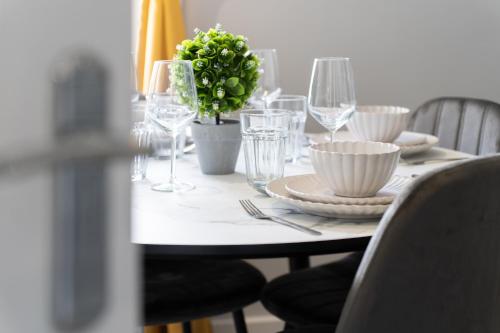 a table with plates and glasses and a plant on it at Open Mind Property - Cosy Apartment with 2 Beds in Portsmouth