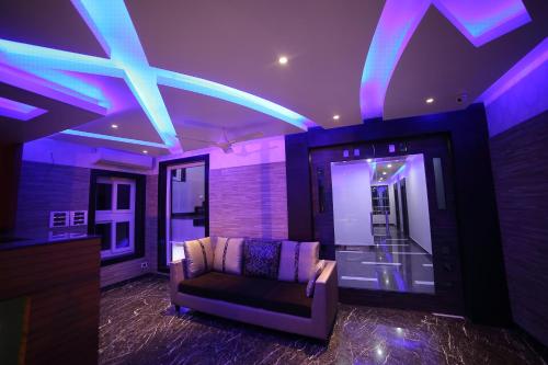 a living room with a couch and purple lights at Vijaya Residency - Porur in Chennai