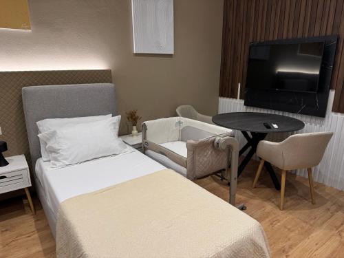 a hotel room with a bed and a table and a tv at Brianza Home in Giussano