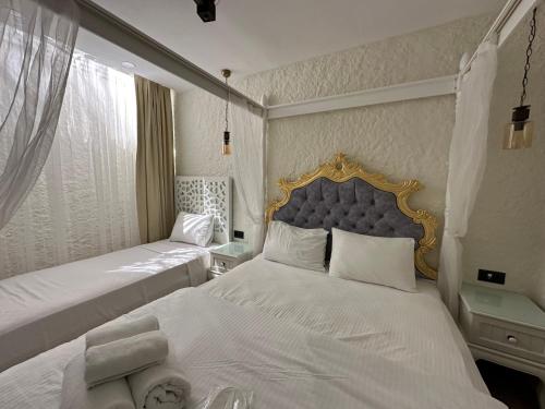 a bedroom with two beds with white sheets and a blue headboard at Grand Alaçatı Butik Hotel in Alacati