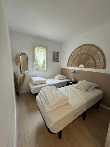 une chambre avec trois lits et une fenêtre dans l'établissement Maison à 5 mn à pied de la plage, à Soulac-sur-Mer