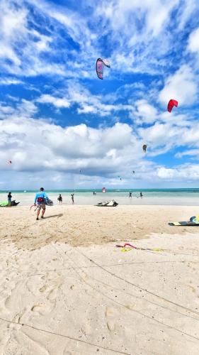 a group of people flying kites on a beach at Tilapasse resto & guest house in Mt Bois Noir
