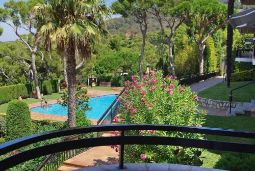 Una vista desde un balcón de una piscina con flores. en Beach apartment overseeing the sea, en Llafranc