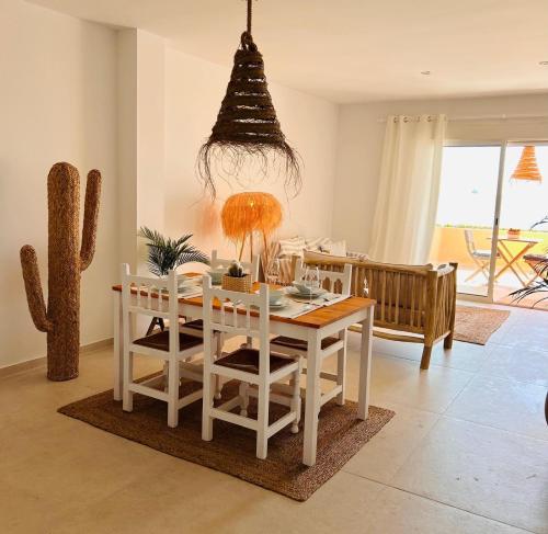 a dining room with a table and a cactus at Beachfront Nudist Apartment in Vera Playa in Playas de Vera