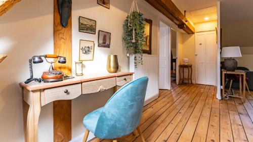 Cette chambre comprend un bureau et une chaise bleue. dans l'établissement Rude - Rétro chic, à Dijon