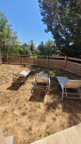 deux tables et chaises dans une cour avec une clôture dans l'établissement Appart dans villa, terrasse et jardin, à Lorgues