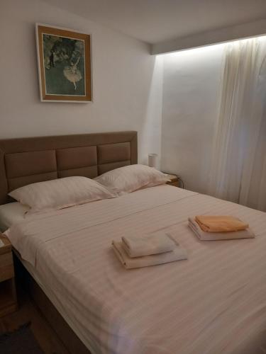 a bedroom with a bed with two towels on it at Apartments Ruzica in Pinezici