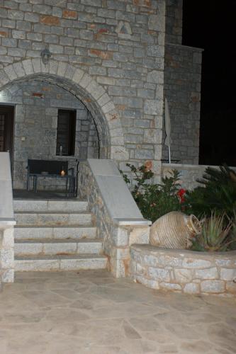 a stone building with a bench in a courtyard at Thelea Mani in Kafióna