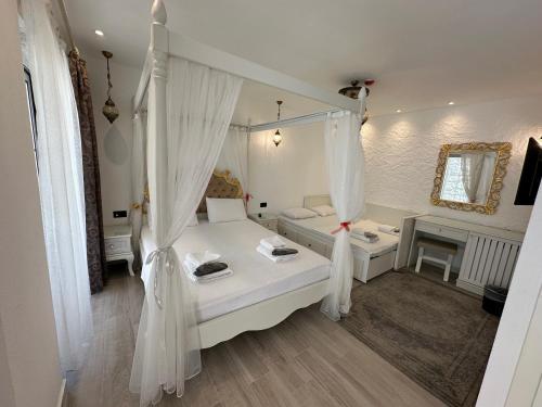 a bedroom with a bed with curtains and a couch at Grand Alaçatı Butik Hotel in Alacati
