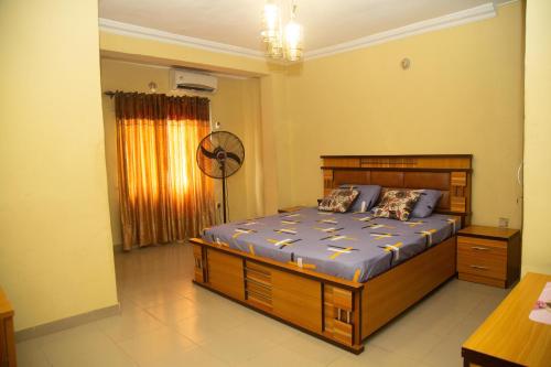a bedroom with a large wooden bed in a room at Home Away from Home - Gowon Estate near Gemade, Ipaja, Lagos in Lagos