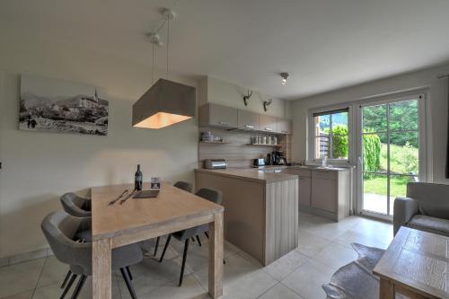 a kitchen and dining room with a wooden table at Residenz an der Burg by Kaprun Rentals in Kaprun