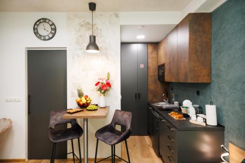 une cuisine avec une table, des chaises et une horloge dans l'établissement Studio apartman Navis, à Slavonski Brod