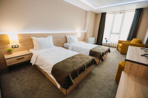 a hotel room with two beds and a couch at Хотел Панорама in Pleven