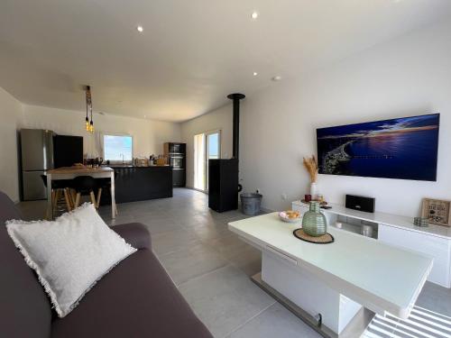 un salon avec un canapé et une table dans l'établissement Maison neuve proche plage avec parking gratuit, à Courseulles-sur-Mer