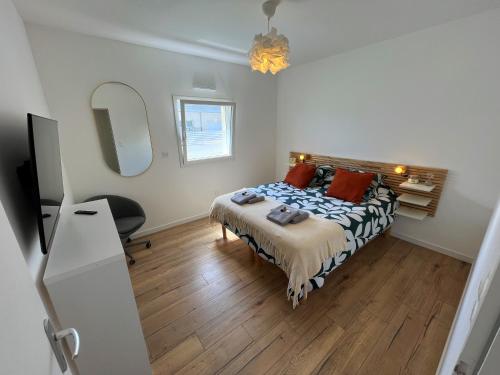 une chambre avec un lit, un bureau et un miroir dans l'établissement Maison neuve proche plage avec parking gratuit, à Courseulles-sur-Mer