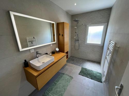 une salle de bain avec un lavabo, un miroir et une douche dans l'établissement Maison neuve proche plage avec parking gratuit, à Courseulles-sur-Mer