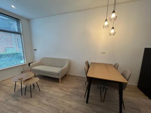 a living room with a table and a couch at Stay and Sleep in Leeuwarden