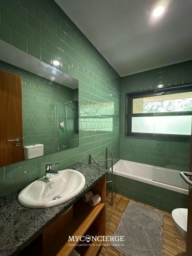 a green tiled bathroom with a sink and a tub at Moleiro da Costa Má in Sever do Vouga