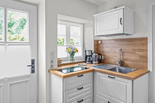 a kitchen with white cabinets and a sink at Lüdersburger Strasse 15b in Lüdersburg