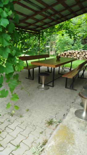 a group of picnic tables and benches under a canopy at Complex Adela Transfăgărășan in Cîrţişoara