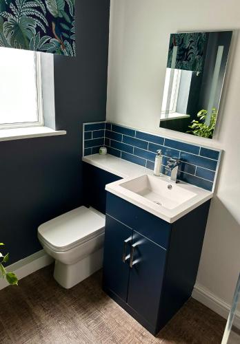 a bathroom with a sink and a toilet and a mirror at Clock Tower Apartments 1 in Morecambe