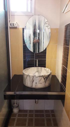 a bathroom with a sink and a mirror at บ้านแฝด 2 ห้องนอน in Khao Kho