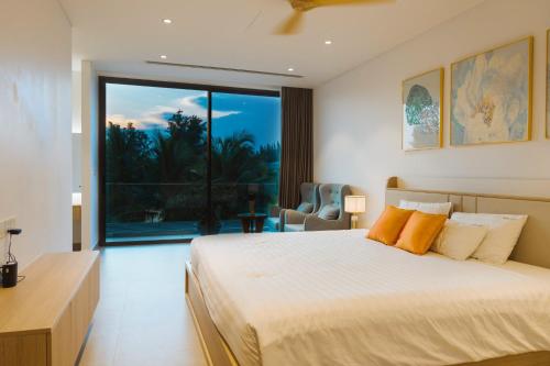 une chambre avec un grand lit et une grande fenêtre dans l'établissement Villa Luxury 5 Phòng ngủ Hồ bơi riêng - Resort Sanctuary Hồ Tràm, à Xuyên Mộc