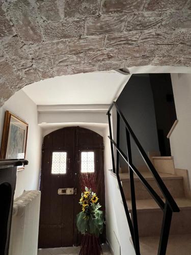 a stairway with a door and a vase of flowers at Le dimore del Mercante in Luco dei Marsi