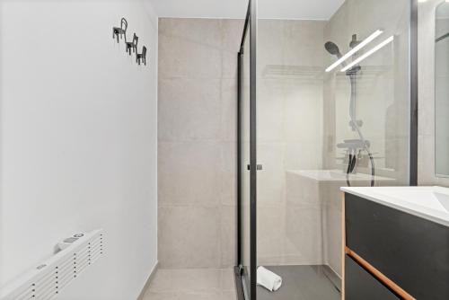 une salle de bain avec douche et lavabo dans l'établissement Marlie s Home - comfort stadsapp met zonnig terras, à Nieuport