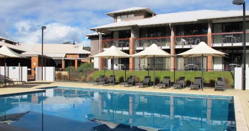 a hotel with a swimming pool in front of a building at Forest Edge Villa - Family Friendly - Walk To Town in Margaret River Town