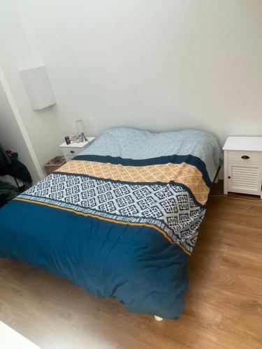 - un lit avec une couette bleue dans une chambre dans l'établissement Villa du Bouscat, à Le Bouscat