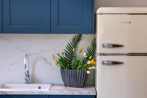 a vase of flowers sitting on a counter next to a refrigerator at Innamorata Sivota in Sivota